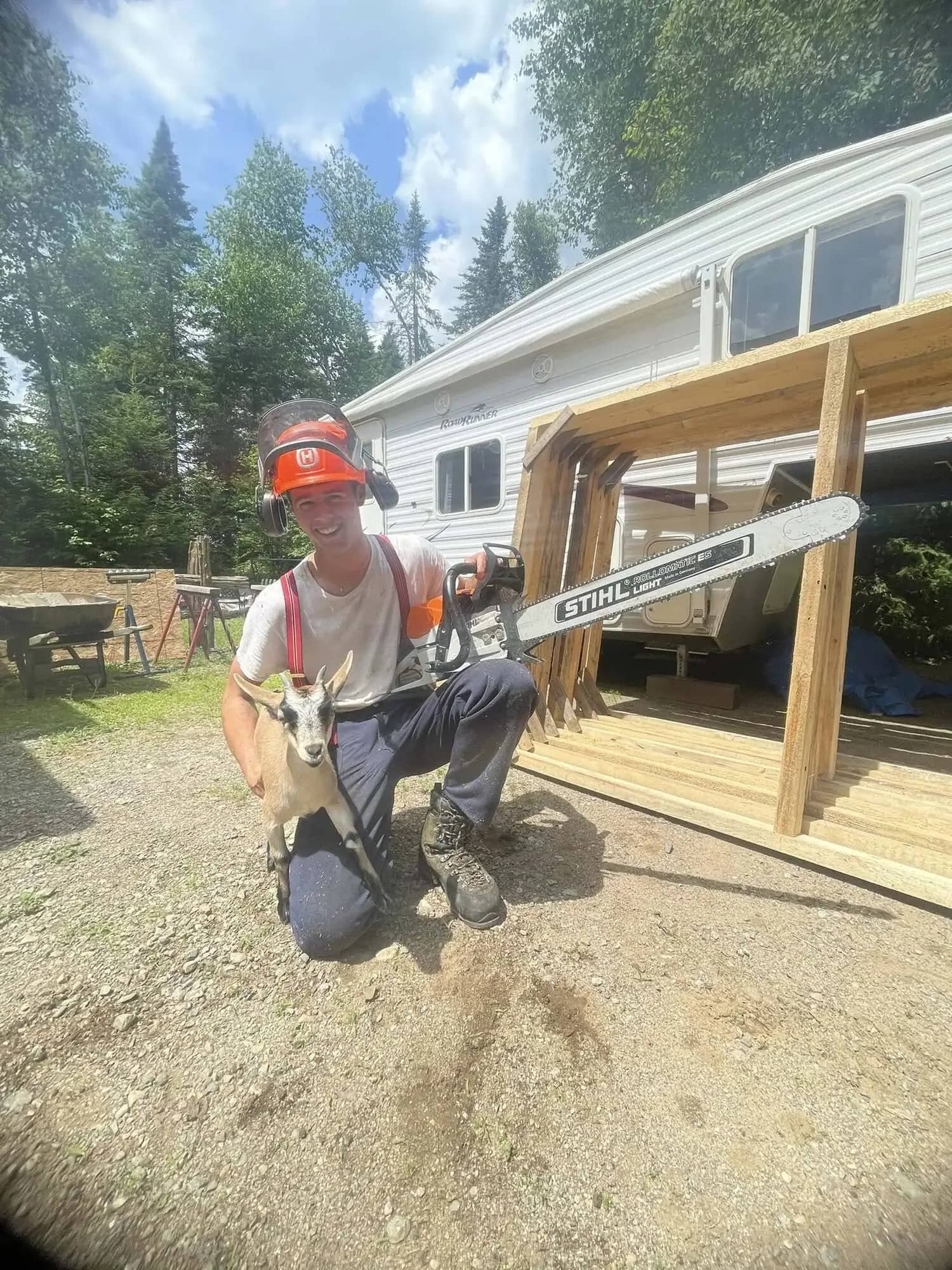 Travailleur Pirax avec une scie à chaîne sur un terrain résidentiel